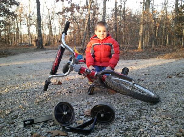 Jackson sits proudly with his "new" bike, without training wheels.