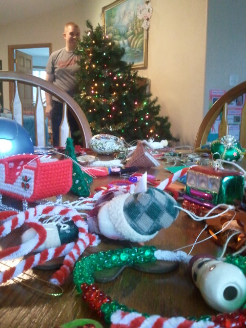Matt holds up the broken tree, while I take off the ornaments and place them on a nearby table.