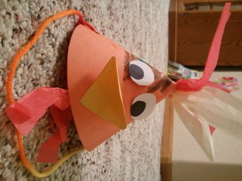We made rooster hats out of construction paper, tissue paper and string.