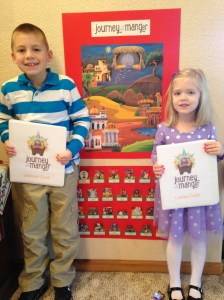 Jackson and Lauren hold their Journey to the Manger activity books in front of our Christmas Countdown board. Each day, we match a person (or animal) to the poster.