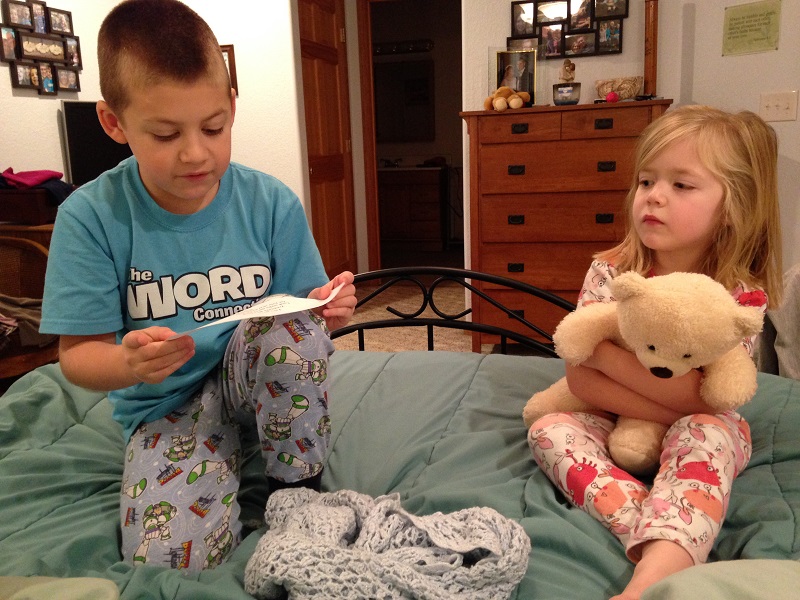 Jackson reads the first clue of our Christmas Treasure Hunt: Let's go on a hunt Treasures wait for you Look under the Christmas tree for your next clue