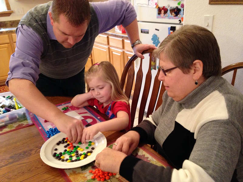 Daddy, Lauren and Grandma work to count their M&Ms in our census.