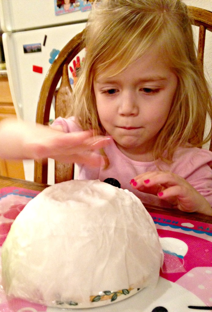 Lauren pats down wet toilet paper to cover a bowl. Though the project wasn't finished today (on purpose!), the kids did get to splash quite a bit of water around.